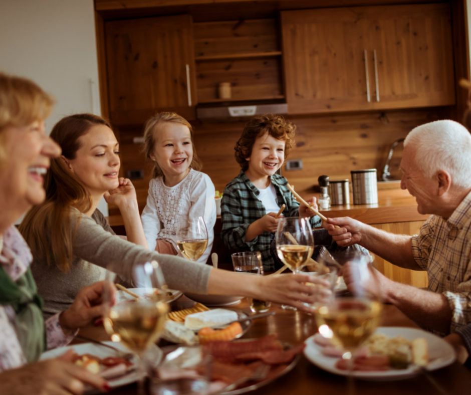 Un repas de famille entre différentes générations : des grands-parents, des parents et leurs enfants.